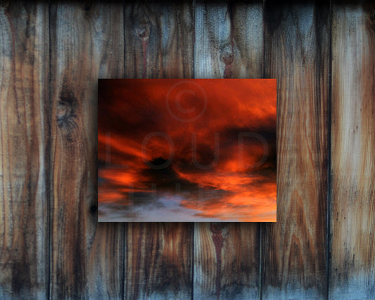 Nature photography print of a fiery sunset with orange and black clouds shown mounted without a frame called Burst by Loud Hue