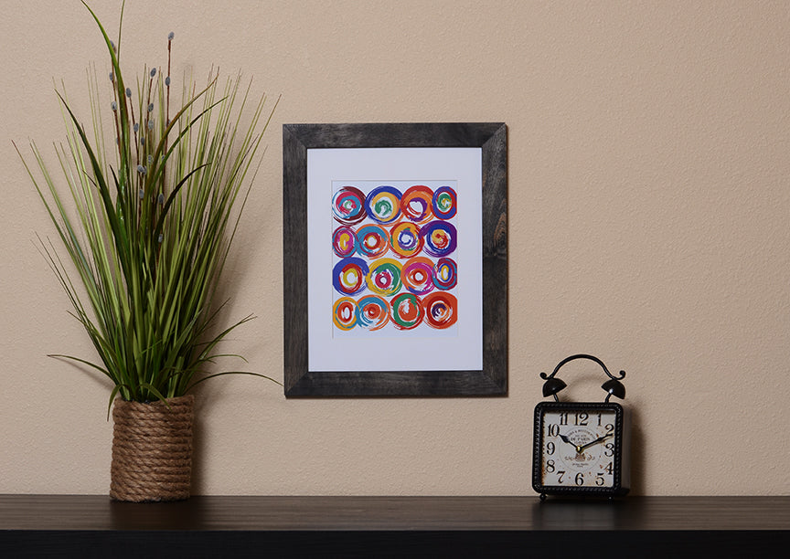 Art Print of energetic and colorful circles with a brushstroke effect shown with a black frame called Jolt by Loud Hue