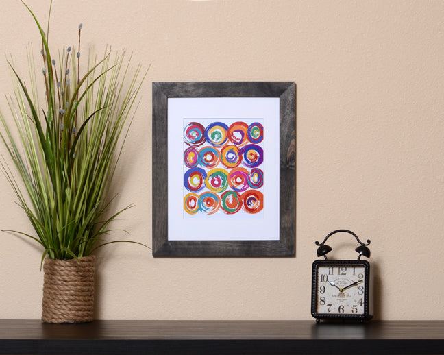 Art Print of energetic and colorful circles with a brushstroke effect shown with a black frame called Jolt by Loud Hue