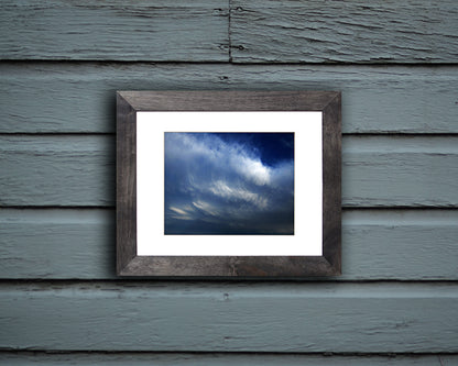 Nature photography print of glorious blue and white clouds shown mounted with a black frame called Blue by Loud Hue