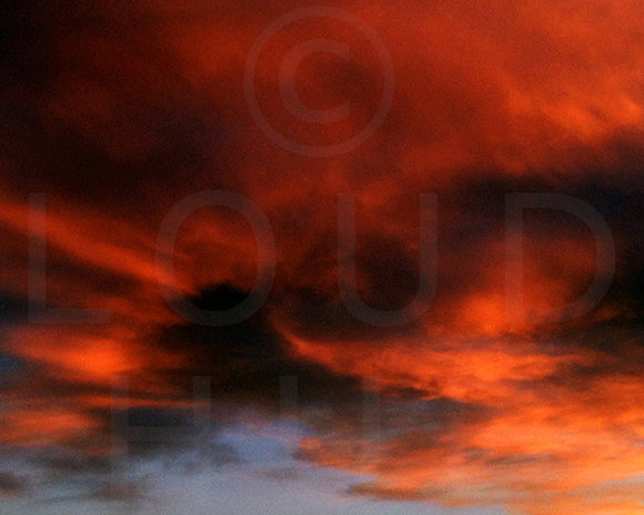 Nature photography print of a fiery sunset with orange and black clouds called Burst by Loud Hue