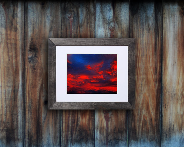 Nature photography print of a glowing red sunset shown mounted with a black frame called Cotton Candy by Loud Hue
