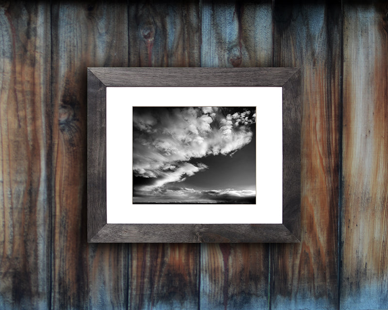Black and White photographic print of a dramatic sky with black frame called Luminous by Loud Hue