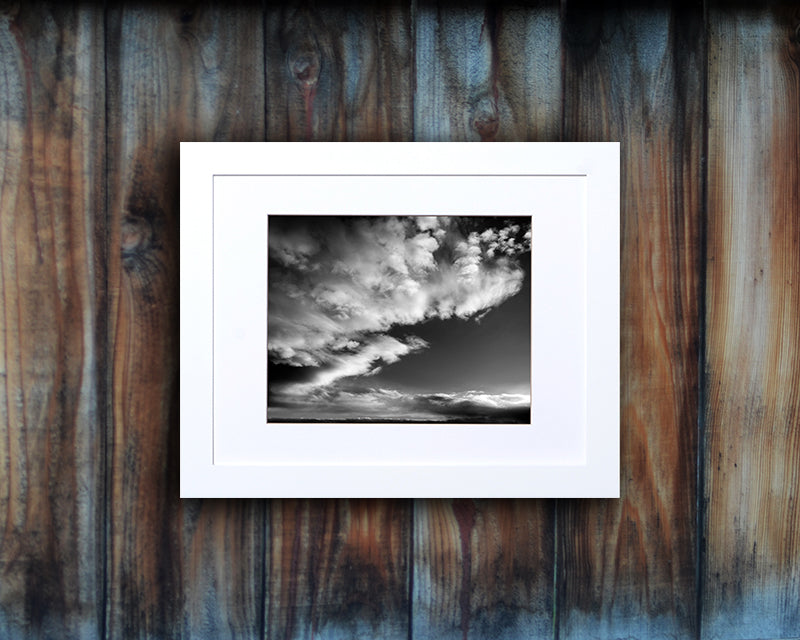 Black and White photographic print of a dramatic sky with white frame called Luminous by Loud Hue