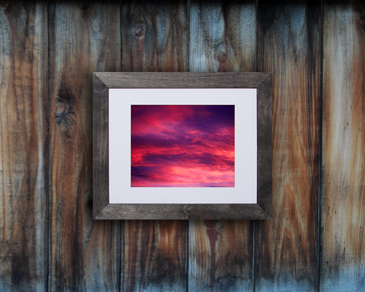 Nature photography print of a gorgeous sunset with vivid hues of violet and fuchsia shown with a black frame called Rose by Loud Hue
