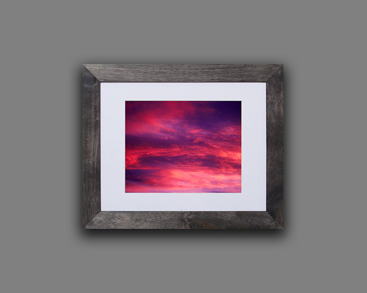 Nature photography print of a gorgeous sunset with vivid hues of violet and fuchsia shown with a black frame called Rose by Loud Hue