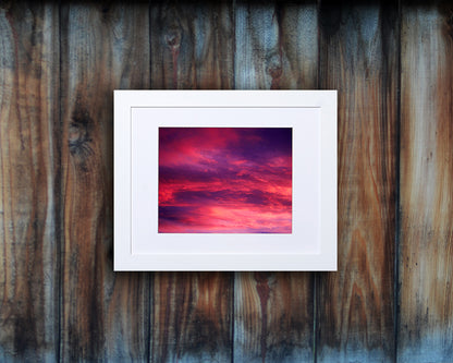 Nature photography print of a gorgeous sunset with vivid hues of violet and fuchsia shown with a white frame called Rose by Loud Hue