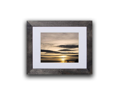 Nature photography print of a peaceful and serene winter sunset shown with a black frame on a white wall called Flawless by Loud Hue