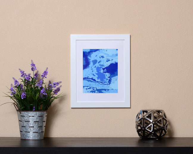 Vibrant Abstract Art Print in the form of waves with hues of blues shown with a white frame called Boundless by Loud Hue